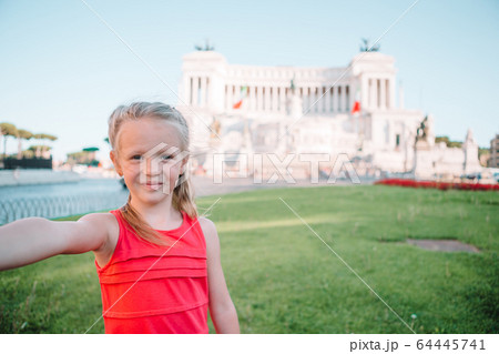Adorable little girl taking selfie in front of Altare della Patria, Vittoriano, Rome, Italy. 64445741