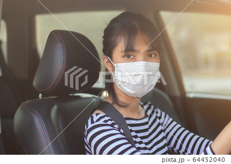 close up face asian young woman driver car wearing medical mask for prevent dust. close up face asian young woman driver car wearing medical mask for prevent dust. 64452040