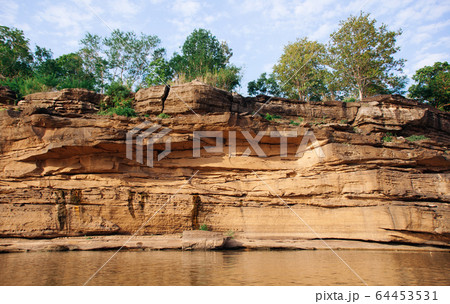 Yellow sandstone canyon cliff shoreline of Mekong river Yellow sandstone canyon cliff shoreline of Mekong river 64453531