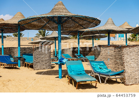 Straw umbrellas and deck chairs in a Red Sea beach - Marsa Alam Egypt Africa 64453759