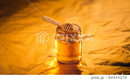 Golden honey in a glass bottle and golden 64454379