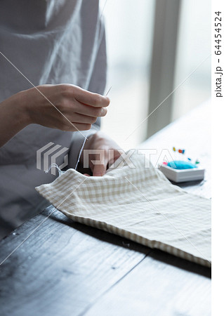部屋の中で裁縫をする若い女性の手元 部屋の中で裁縫をする若い女性の手元 64454524