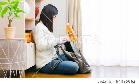 ペットボトル飲料をリュックに入れる女性　お茶　コピースペース　16:9 64455062