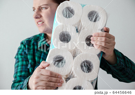 Buying Essentials. Young woman took the last package of toilet paper from a store shelf due to the spread of coronavirus infection 64456646