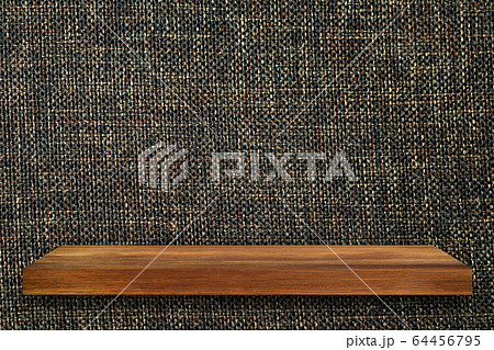 Empty top of wooden shelves on fabric wall 64456795