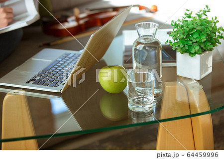 Young woman studying at home during online courses or free information by herself, focus on table 64459996
