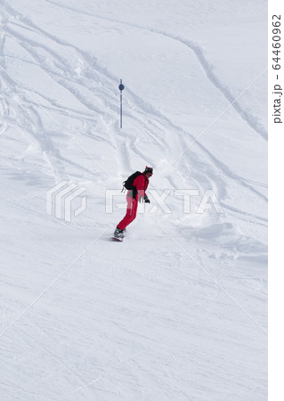 Snowboarderdescends on snowy ski slope after 64460962