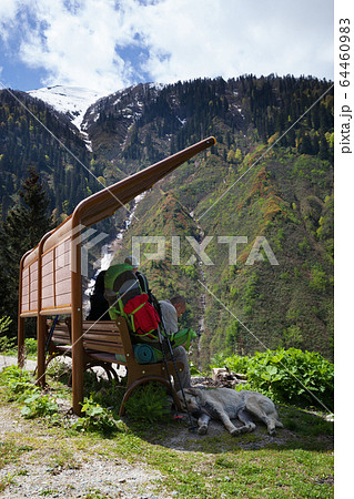 Hikers with big backpacks resting on wooden chair Hikers with big backpacks resting on wooden chair 64460983