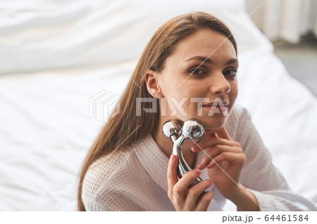 Relaxed lady holding a y-shaped massage roller Relaxed lady holding a y-shaped massage roller 64461584