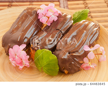 Eclair with chocolate custard decorated with pink flowers 64463645