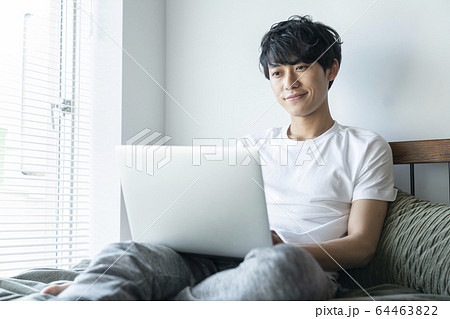 ノートパソコンの画面を見る若い男性 ノートパソコンの画面を見る若い男性 64463822