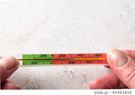 Woman hands holding mercury thermometer on white background. Fever and healthcare concept. Top view 64463838