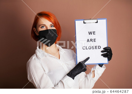 Woman holding blank with inscription we are closed calling for stop spreading covid-19 Woman holding blank with inscription we are closed calling for stop spreading covid-19 64464287