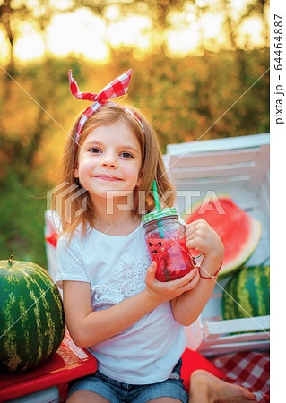 Child drinking Watermelon lemonade in jar with ice and mint as summer refreshing drink. Cold soft drinks with fruit 64464887