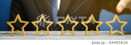 Businessman points to the fifth star. The concept of the rating of hotels and restaurants. The evaluation of visitors. Quality level, good service. Best customer rating. Feedback. Satisfaction. Banner Businessman points to the fifth star. The concept of the rating of hotels and restaurants. The evaluation of visitors. Quality level, good service. Best customer rating. Feedback. Satisfaction. Banner 64465616
