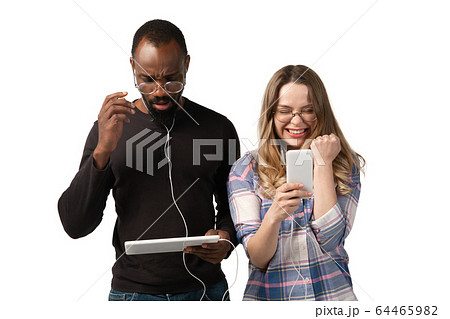 Emotional man and woman using gadgets on white studio background, technologies connecting people. Gaming, shopping, online meeting 64465982