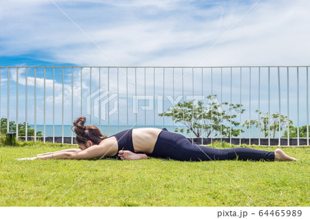 Happy Asian woman wearing black sport wear practice yoga Pigeon pose with beautiful sea view,Feeling relax and comfortable,Healthy Concept 64465989