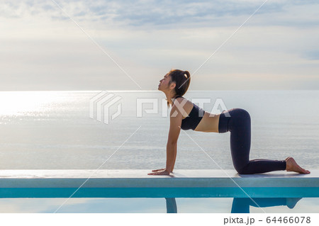 Asian woman practice yoga Cat Pose on the beach in the morning,Feeling so comfortable and relax in holiday,Healthy Concept Asian woman practice yoga Cat Pose on the beach in the morning,Feeling so comfortable and relax in holiday,Healthy Concept 64466078