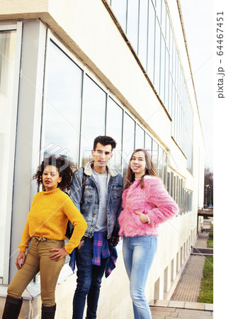 cute group of teenages at the building of university with books huggings, diversity nations real students lifestyle 64467451