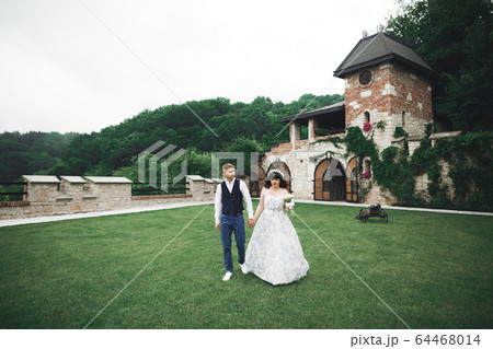 Happy wedding couple walking in a botanical park 64468014