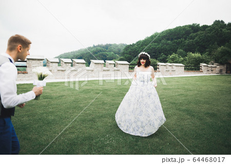 Romantic wedding moment, bride running from groom in a park 64468017