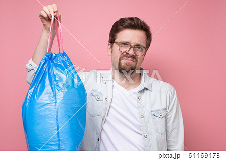 Handsome man holding blue garbage bag isolated on Handsome man holding blue garbage bag isolated on 64469473