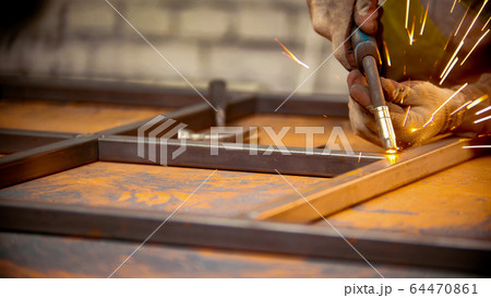 Grinding the seams of metal frame in the workshop Grinding the seams of metal frame in the workshop 64470861