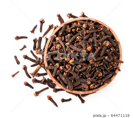 Clove spice in a wooden plate on a white 64471116