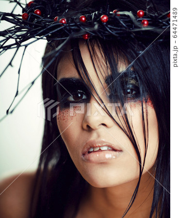 pretty brunette woman with make up like demon at halloween, dark scary look for holiday celebration pretty brunette woman with make up like demon at halloween, dark scary look for holiday celebration 64471489