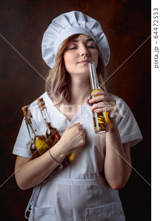 Young beautiful girl in a chef uniform with small Young beautiful girl in a chef uniform with small 64472553