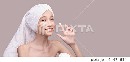 Young girl apply anti age cream. Skin care routine Young girl apply anti age cream. Skin care routine 64474654