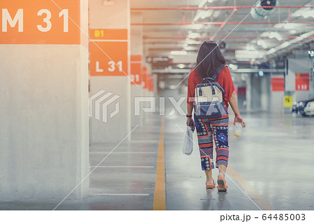 A lonely Asian woman forgot and  can't find her car at underground parking after the mall is closed. 64485003