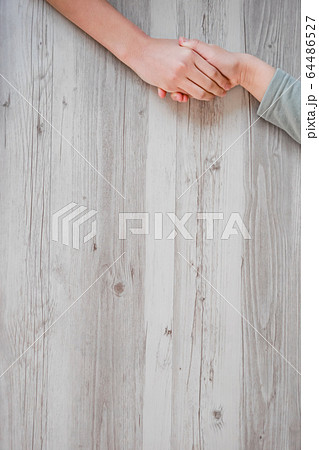 テーブルの上で手をつなぐ子供 64486527