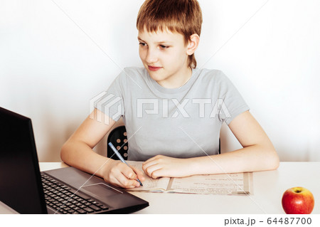 Distance learning at home. Schoolboy sitting at 64487700