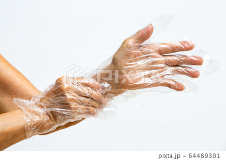 Senior woman's hands wearing disposable protective plastic glove on grey background, Close up shot, Prevention from covid19, Coronavirus, Bacteria, Healthcare 64489301