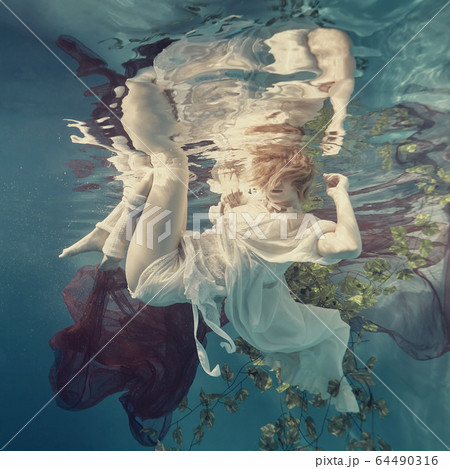 Portrait of a girl floating underwater 64490316