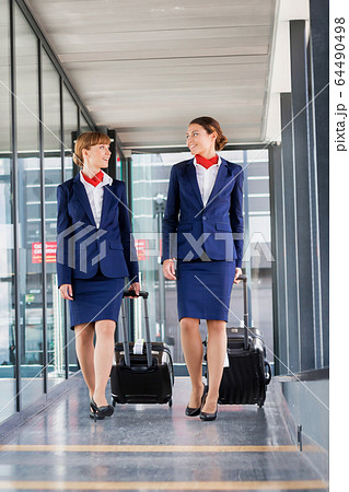 Portrait of attractive flight attendants walking Portrait of attractive flight attendants walking 64490498
