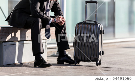 Mature businessman sitting while waiting in the Mature businessman sitting while waiting in the 64491060
