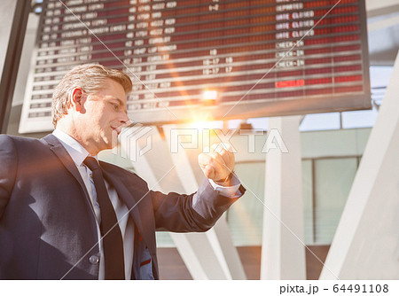 Portrait of mature businessman checking time on 64491108