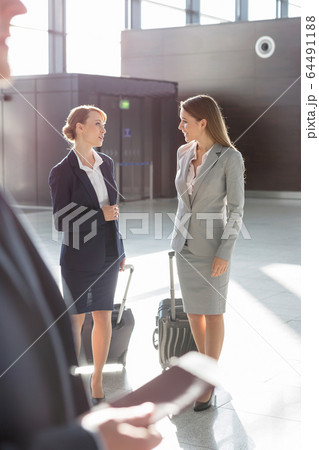 Businesswomen discussing plans while walking with Businesswomen discussing plans while walking with 64491188