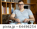 The quarantined guy works remotely from home. Communication, people and freelance work concept 64496254