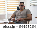 The quarantined guy works remotely from home. Communication, people and freelance work concept 64496264