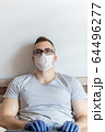 The quarantined guy works remotely from the hospital. Communication, people and freelance work concept 64496277