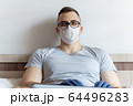 The quarantined guy works remotely from the hospital. Communication, people and freelance work concept 64496283