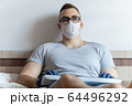 The quarantined guy works remotely from the hospital. Communication, people and freelance work concept 64496292