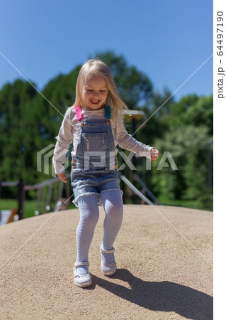 Portrait of happy blonde 4 years girl playing on playground 64497190