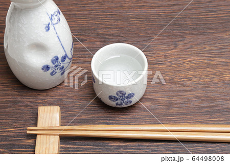 食卓に置かれた日本酒と猪口と箸 食卓に置かれた日本酒と猪口と箸 64498008