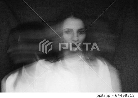crazy portrait of girl with mental disorders and split personality. Black and white with added grain and motion blur 64499515
