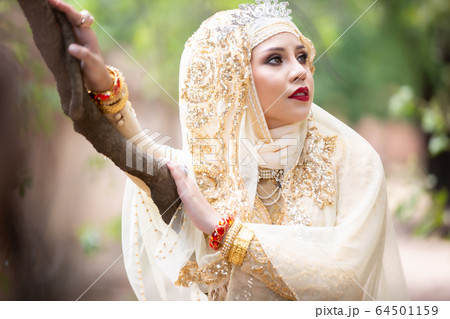 Portrait Of Young Bride Wearing wedding Hijab Standing outdoor 64501159