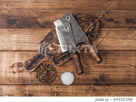 Vintage hatchets for meat on wooden chopping board Vintage hatchets for meat on wooden chopping board 64502399